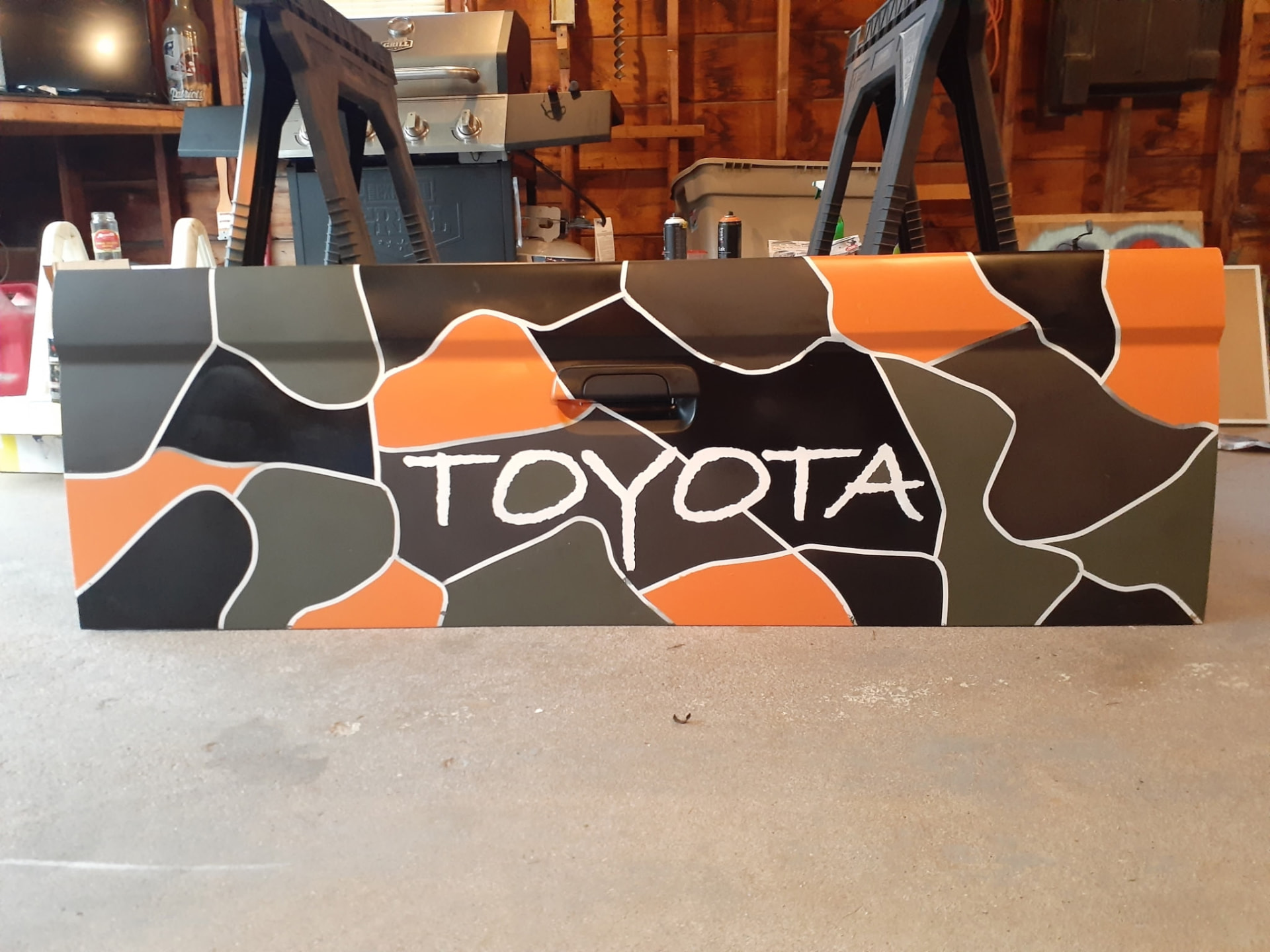 Hand-painted black, gray, and orange Toyota truck panel
