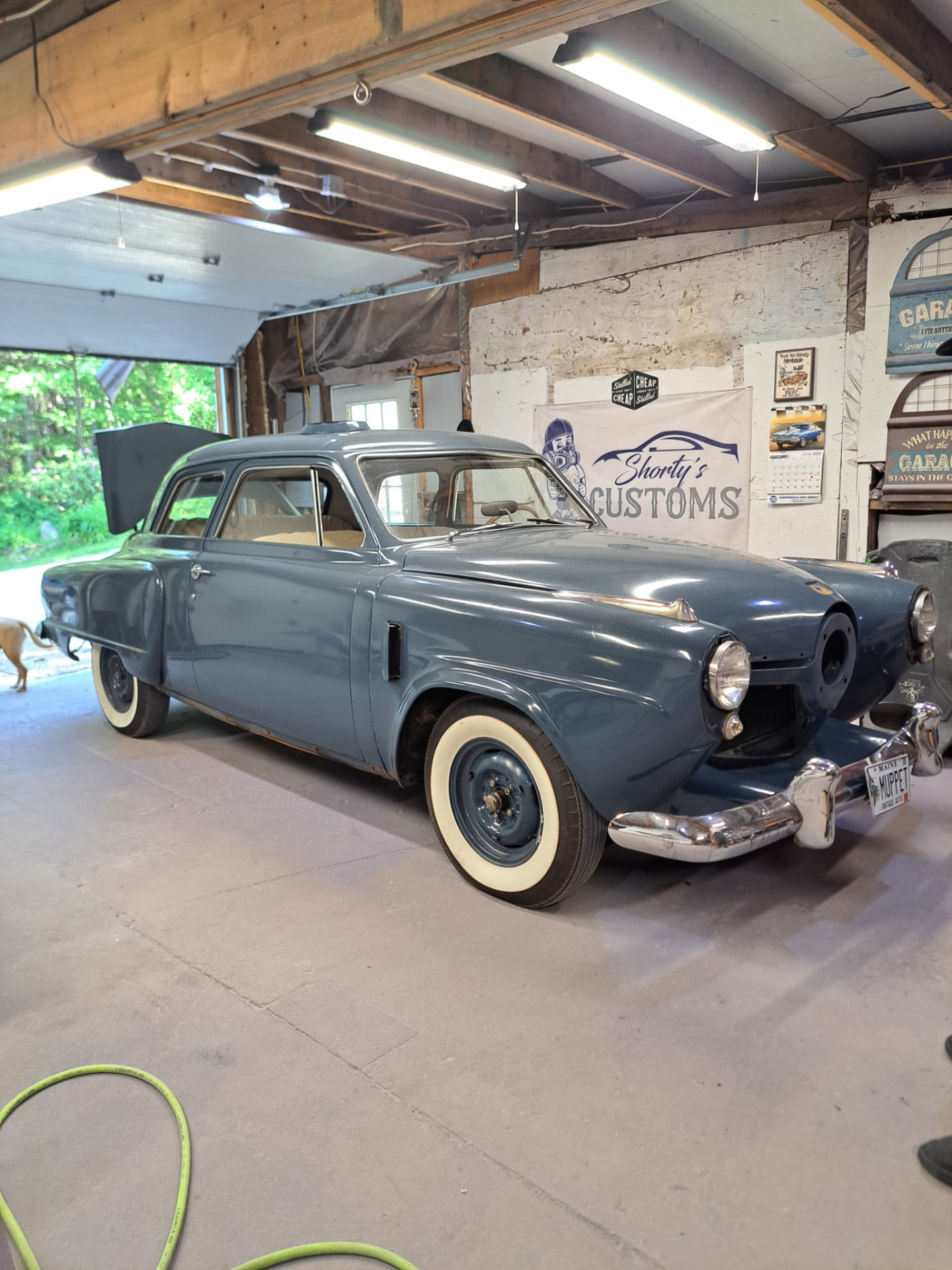 Steel blue vintage sedan with whitewall tires at the shop