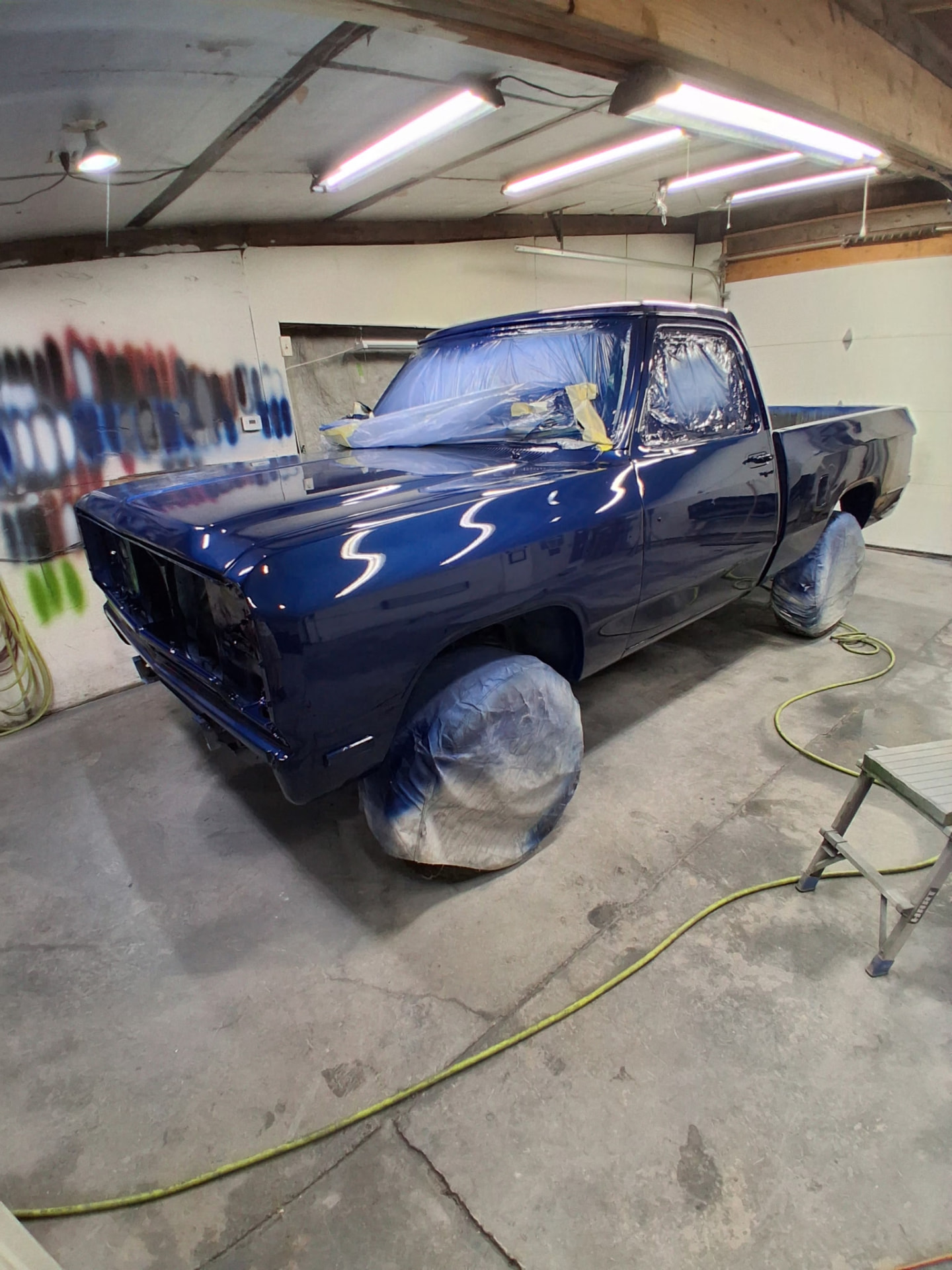Blue custom-painted pickup truck inside the workshop
