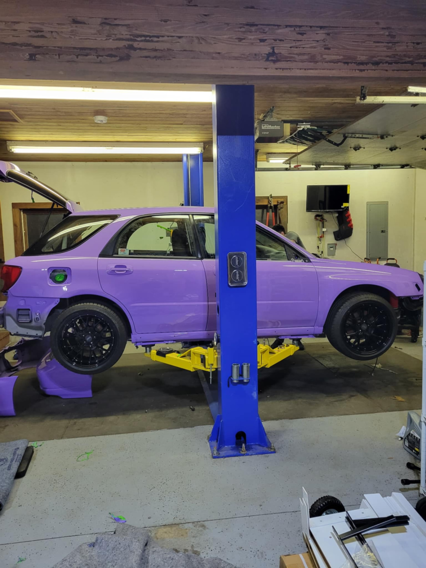 Purple custom car on a lift in the workshop